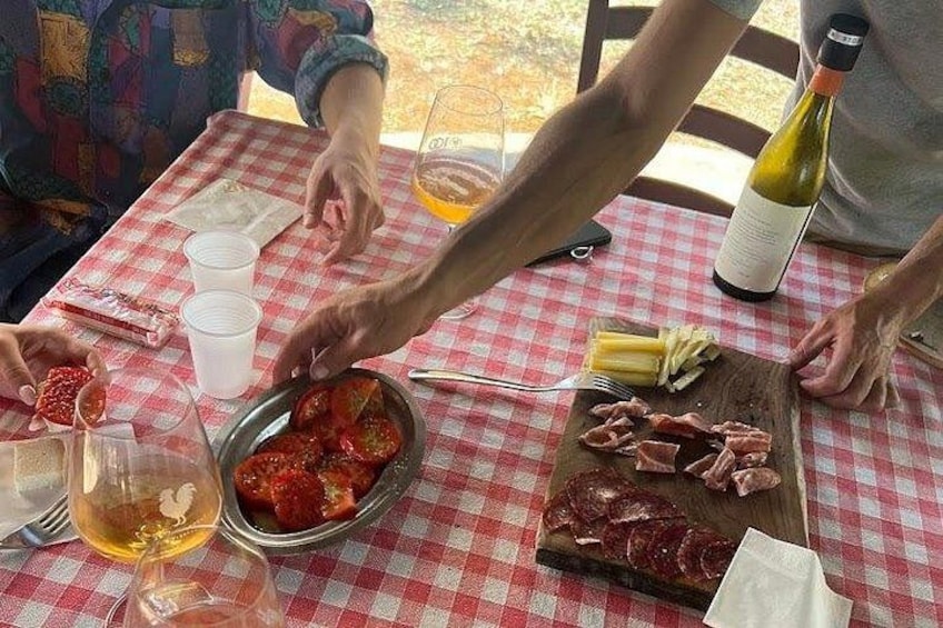 Et bord med dug i tern, en flaske vin, en skål med jordbær og en skærebræt med kød. 4