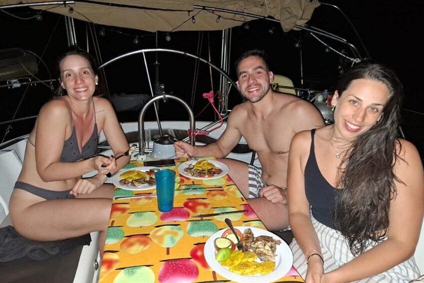 Three people dining on a boat with a colorful tablecloth. 3