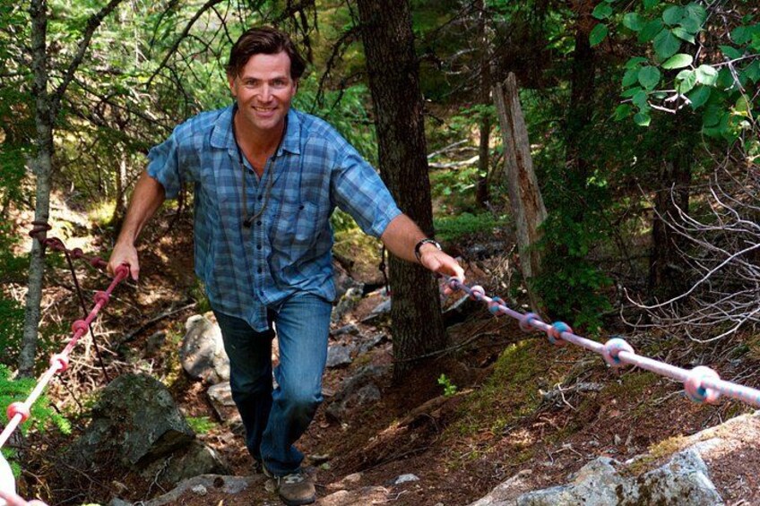 A person hiking on a trail in a forested area. 1