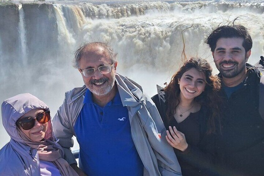 A group of people standing in front of a waterfall. 2