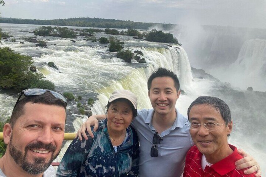 A group of people standing in front of a waterfall. 5