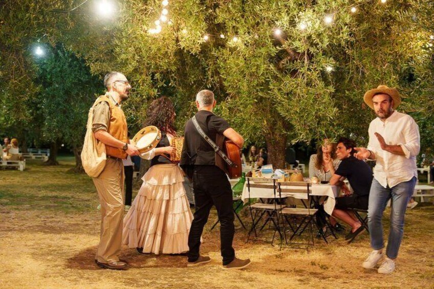 People playing musical instruments and dancing outdoors at night. 5