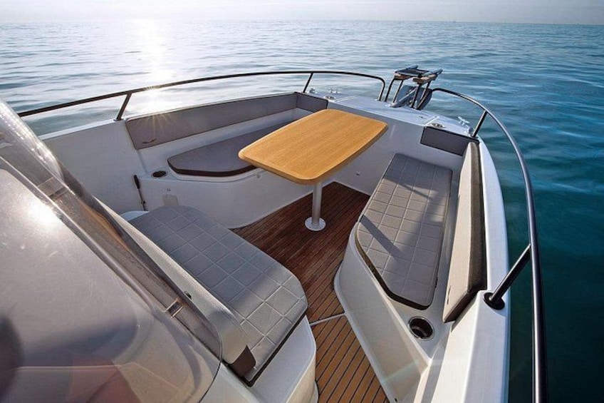 A boat's deck with a table and cushioned seating. 4