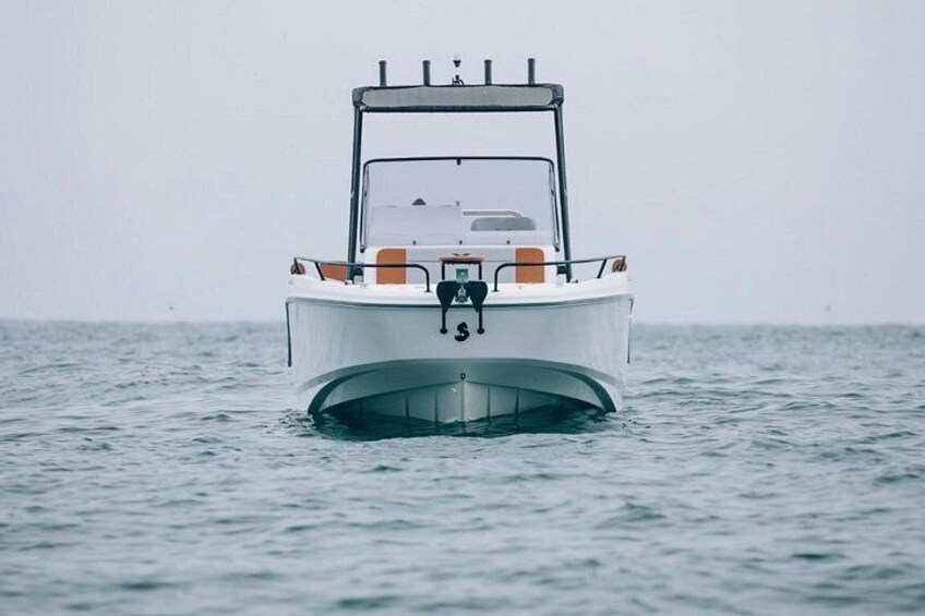 A boat with a cabin and seating, floating on calm water. 2