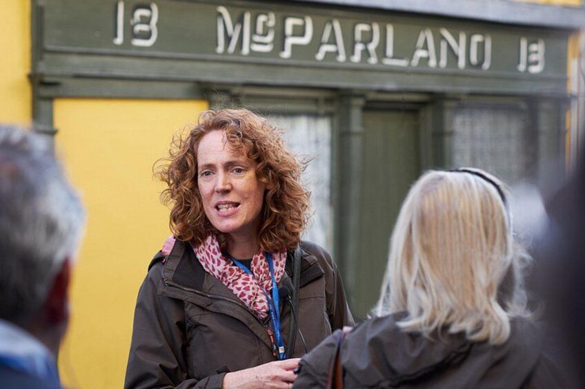 A person standing in front of a building with the number 13 and the name 'McPARLANO' visible. 2