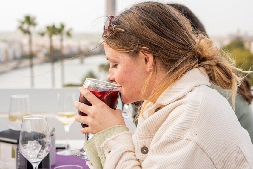 Una persona sentada a una mesa con una copa de vino tinto y otra de vino blanco. 5