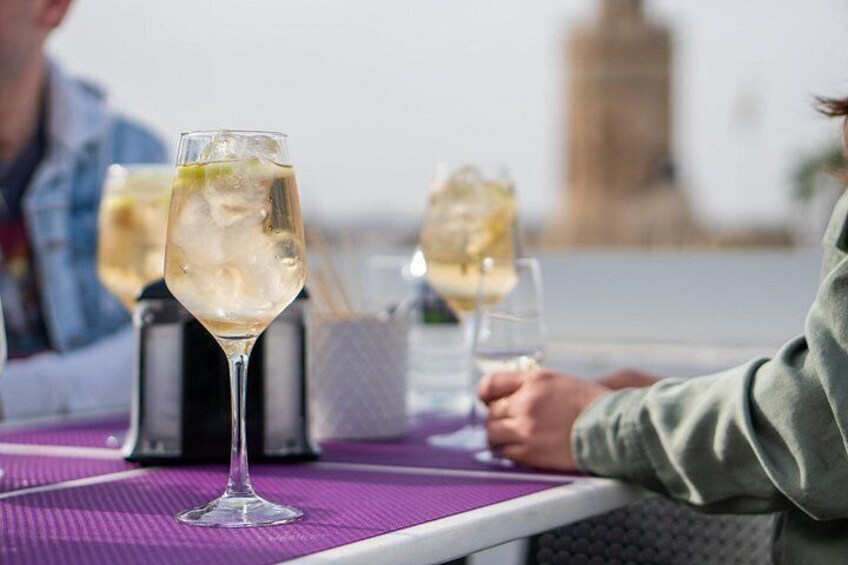 Una mesa con bebidas y un paisaje urbano al fondo. 4