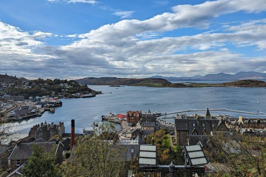 A coastal town with historic buildings, a harbor, and a mountainous backdrop. 2