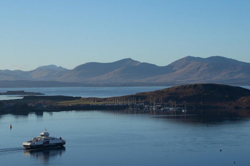 A calm lake with a boat, distant mountains, and a dock with boats. 4