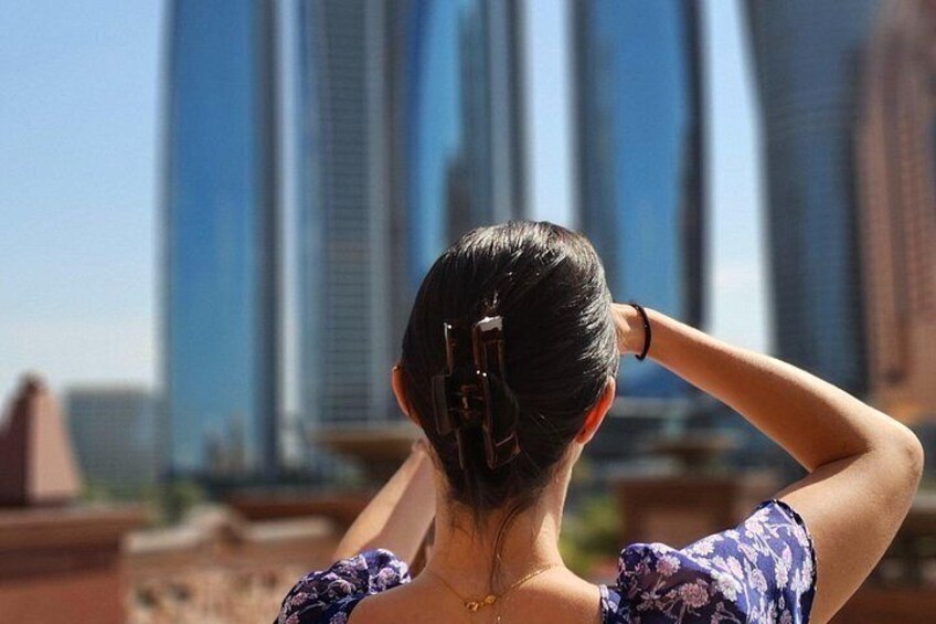 Une personne aux cheveux coiffés en arrière, qui surplombe un paysage urbain avec de hauts immeubles. 3