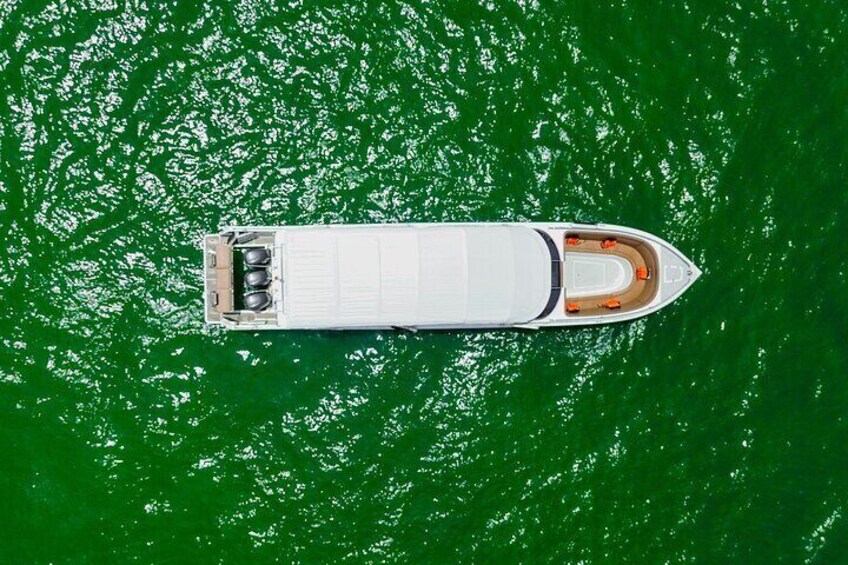 A white boat with orange accents on a green body of water. 5