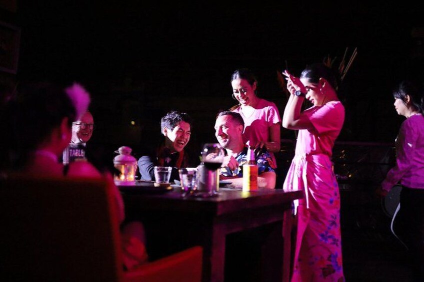 A group of people at a table with drinks and a bottle of water. 2
