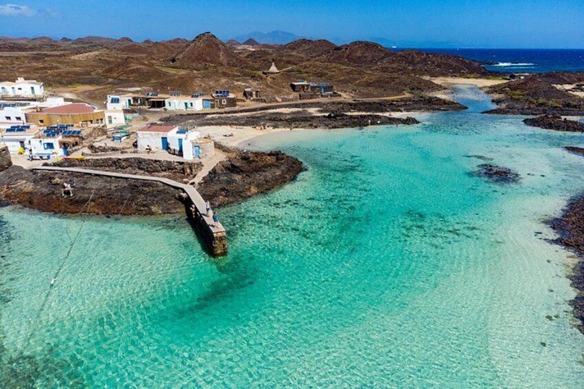 Una zona costera con un puente, aguas turquesas cristalinas y edificios en la orilla. 3