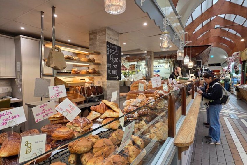 Una vetrina di panetteria con diversi prodotti da forno e cartelli che indicano prezzi e tipologie. 3