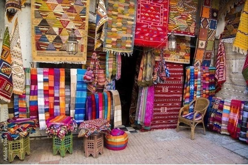 A variety of colorful textiles and rugs displayed in a shop. 4