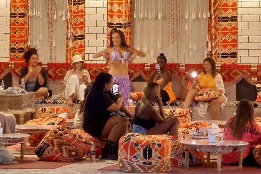 A group of people sitting around tables in a decorated indoor setting. 4