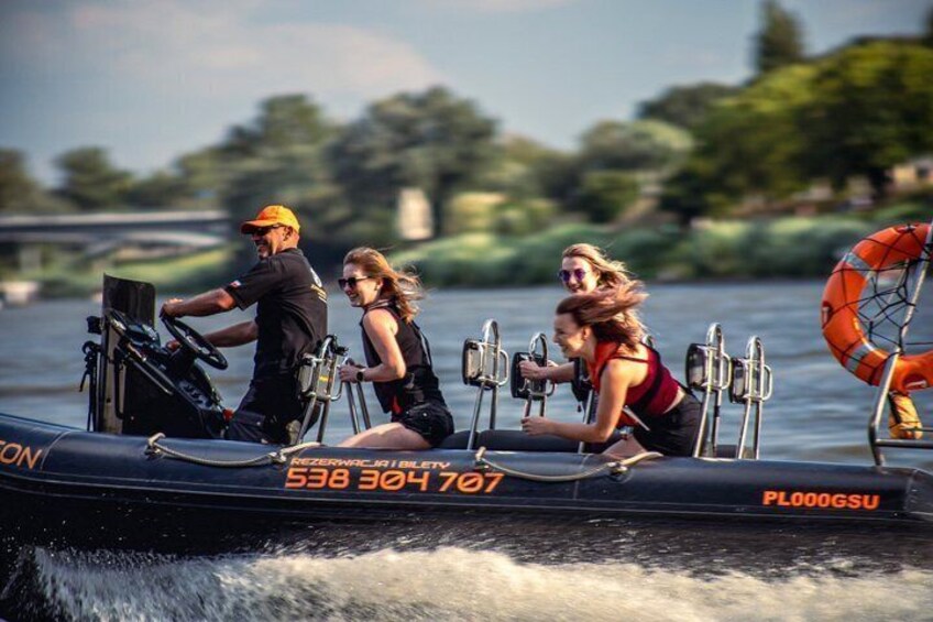 A boat with people on it, a bridge in the background, and trees along the water. 4