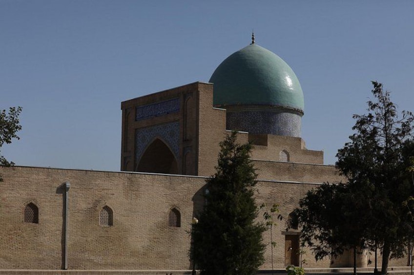 Una mezquita con una gran cúpula verde y un minarete. 4