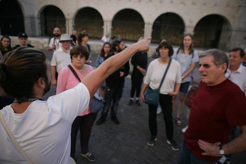 A group of people in an outdoor setting with arches in the background. 2