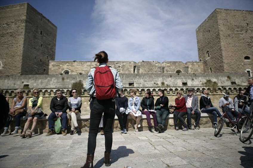 Un groupe de personnes est assis sur un mur de pierre, avec un château en arrière-plan. 5