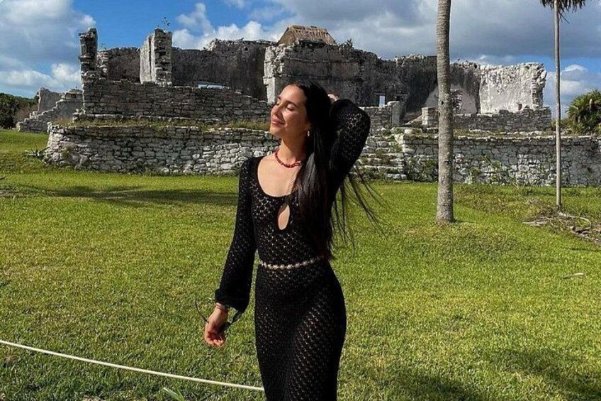 Una persona de pie frente a ruinas antiguas bajo un cielo despejado. 1