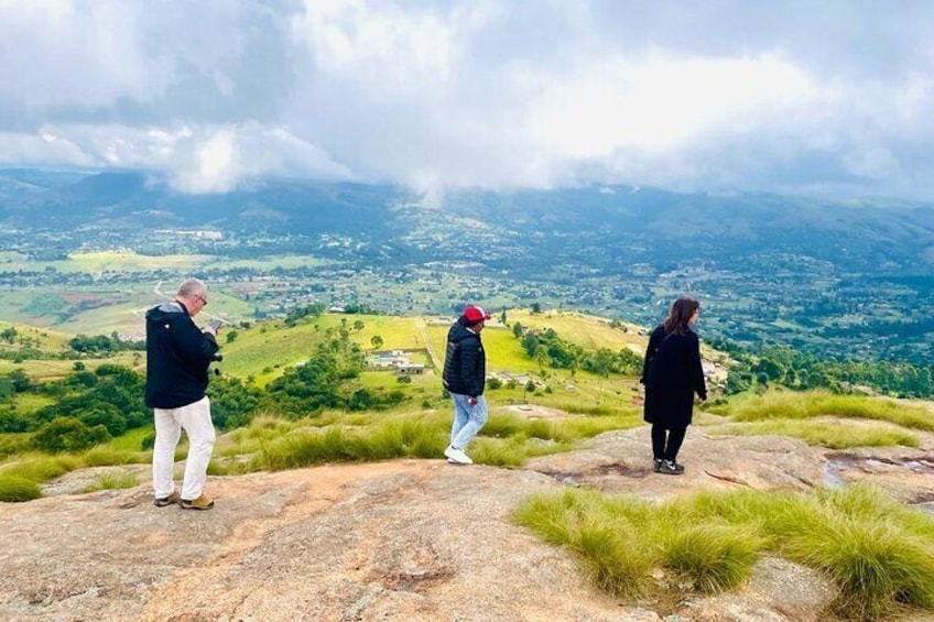 Trois personnes se tiennent debout sur un promontoire rocheux, d’où elles dominent une vallée. 1