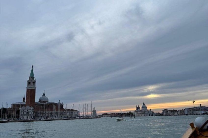 A waterfront cityscape with a prominent tower and domed buildings under a cloudy sky. 4