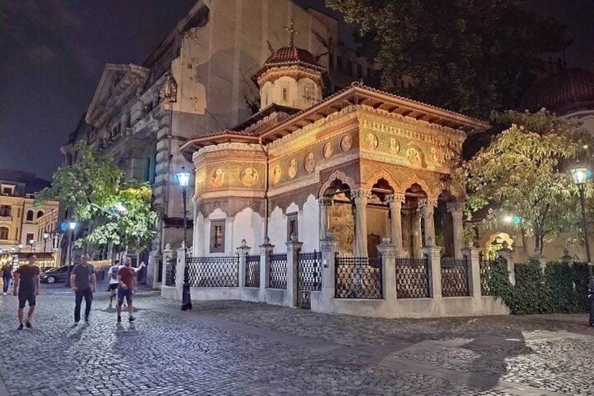 Ein historisches Gebäude mit aufwendiger Architektur, eine Kopfsteinpflasterstraße und einige Fußgänger. 4