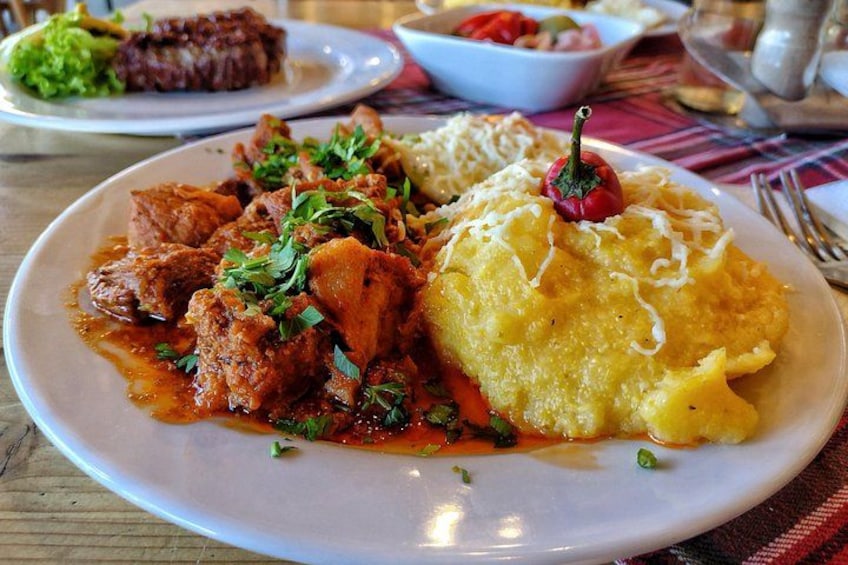 A plate of food with a red sauce, a yellow dish, and a green garnish. 2