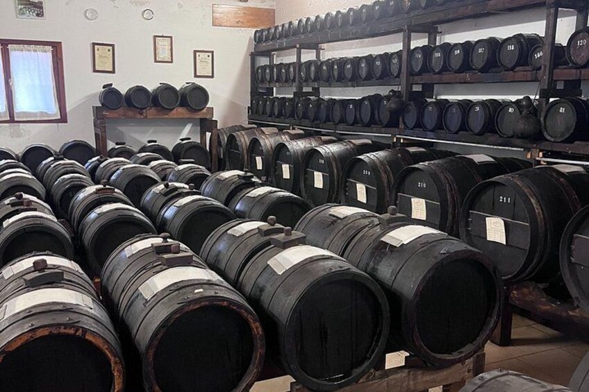 Rows of large black barrels stacked in a warehouse. 3
