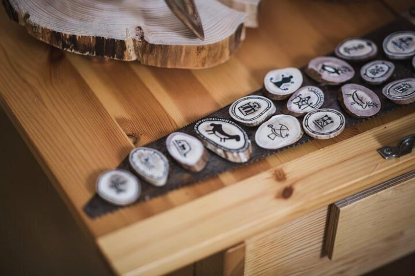 A wooden surface with a row of circular objects, each with a unique symbol. 1