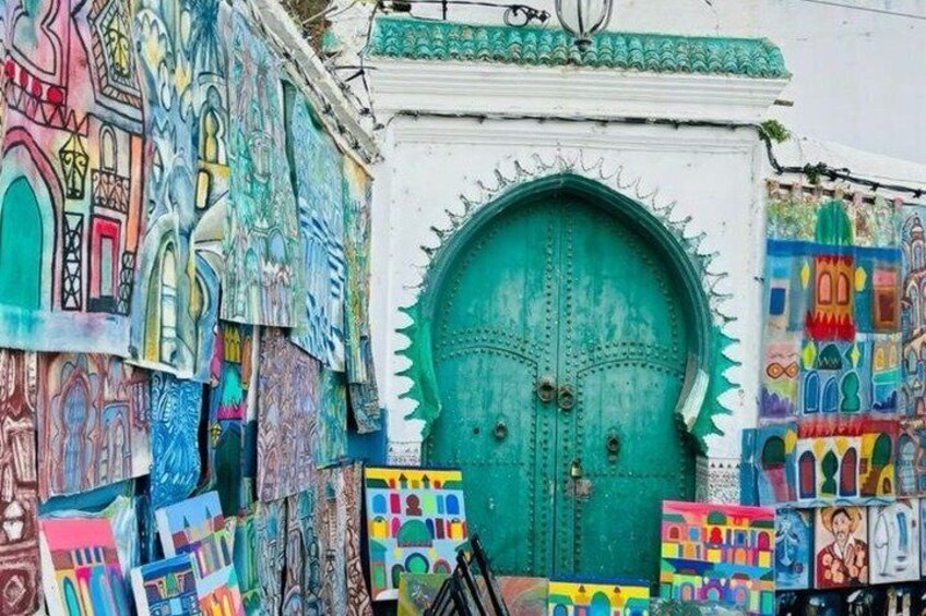 Una porta turchese con elaborate decorazioni in metallo, circondata da vivaci murales. 1