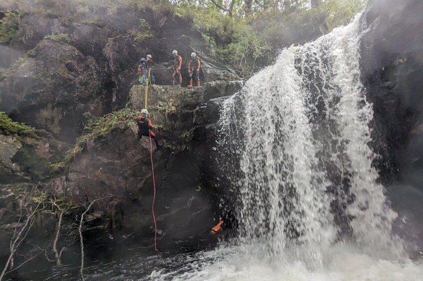 A waterfall with people engaged in rappelling. 3