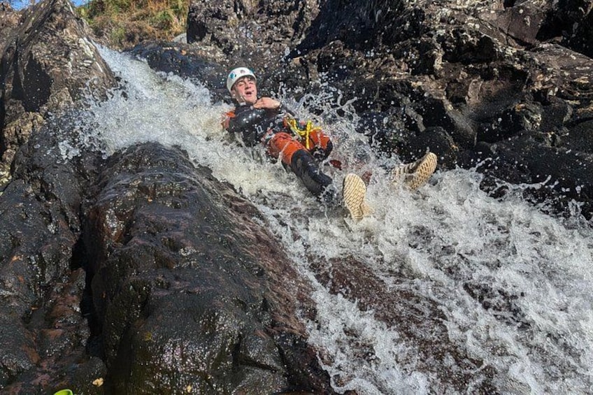 A person in a helmet and life jacket navigating a turbulent river. 5