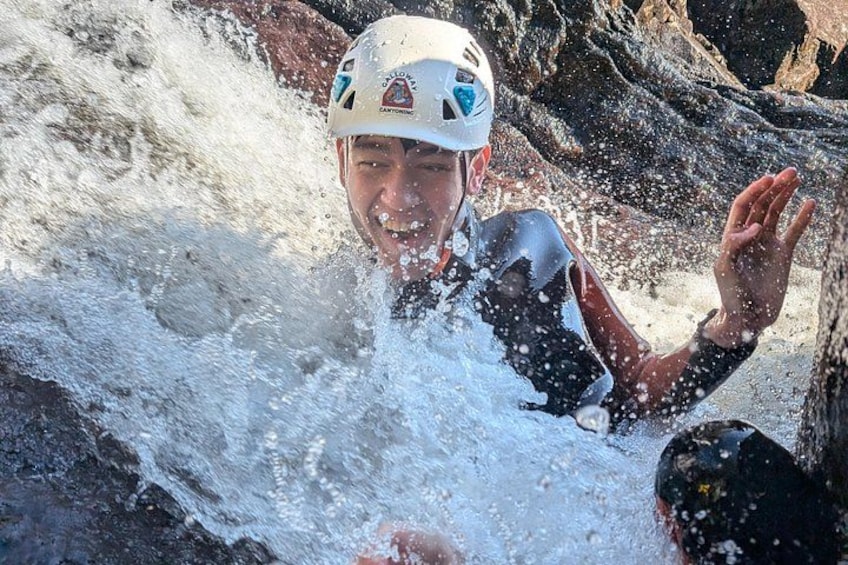 A person in a helmet and wetsuit, partially submerged in water, with splashes around. 4