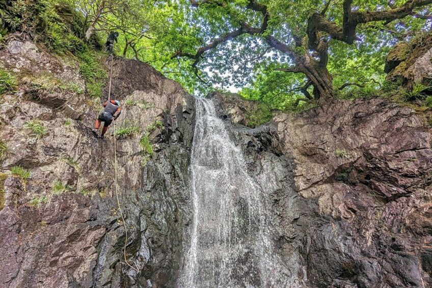 A person rappelling down a waterfall. 2
