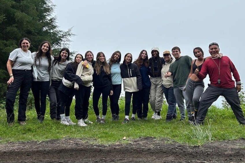 Un grupo de personas de pie en un campo cubierto de hierba, con árboles al fondo. 1