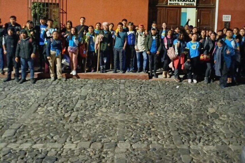 Un gruppo di persone in piedi di fronte a un edificio con un cartello che riporta la scritta 'MESTER TOUR'. 5