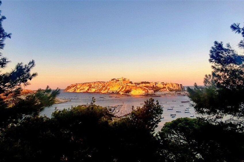 A coastal landscape with cliffs, boats, and trees. 4