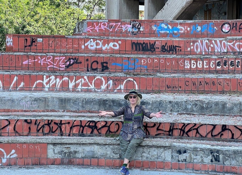 A person standing on a staircase with graffiti on the steps. 5