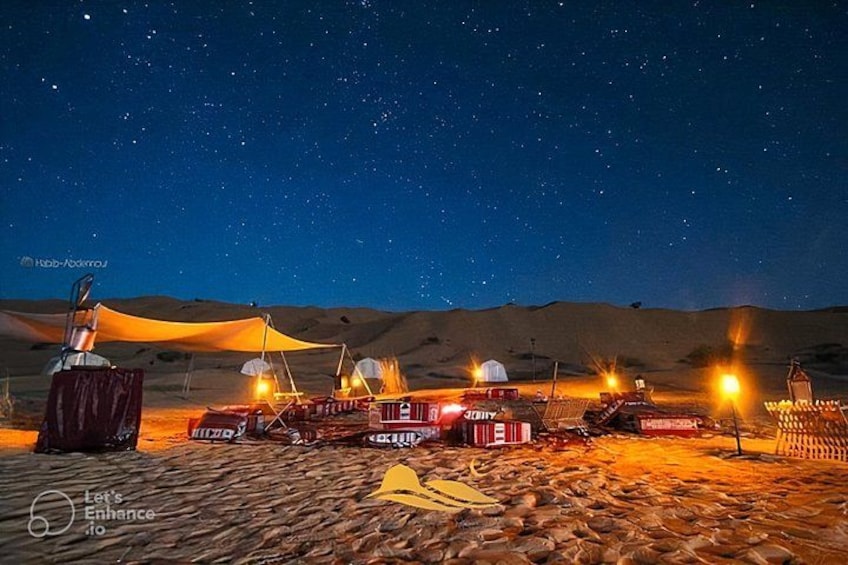 Campa de noche en el desierto con tiendas de campaña, un telescopio y un cielo estrellado. 1