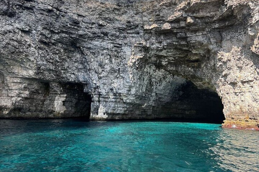 Une falaise rocheuse, au pied de laquelle se trouve une étendue d’eau d’un bleu limpide. 2