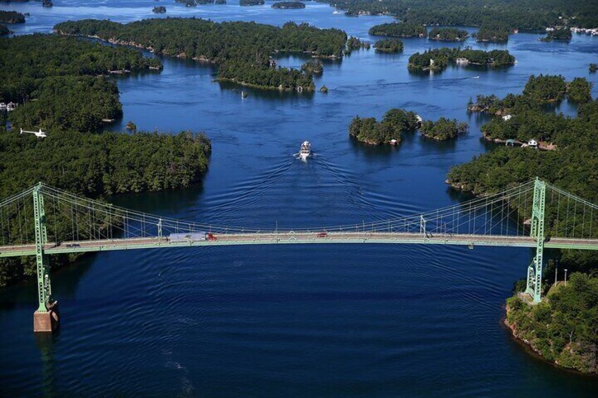 A green suspension bridge over a body of water with several islands. 5