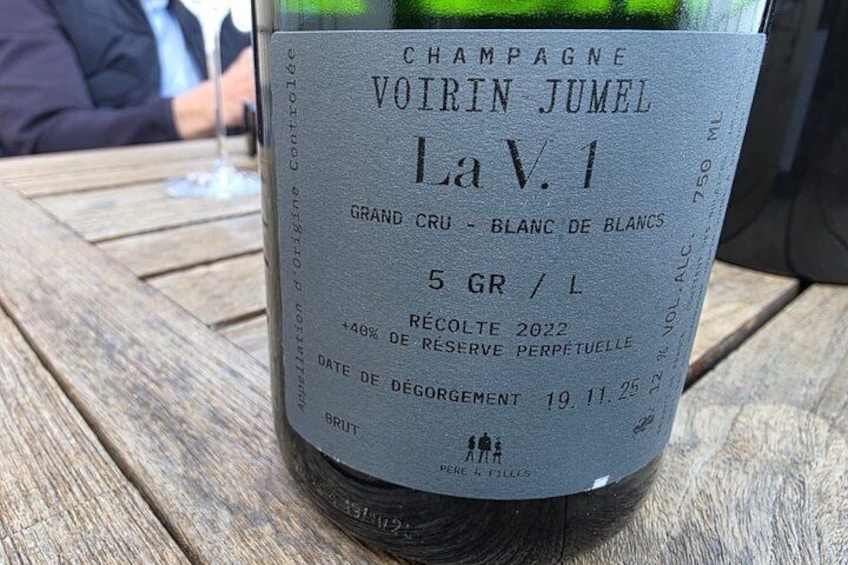 En flaske Champagne med etiket, der angiver at det er en 5 GR/L La V.1 fra år 2022. 4
