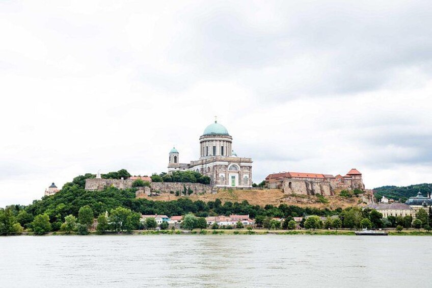 A historic building with a dome, situated on a hill by a body of water. 3
