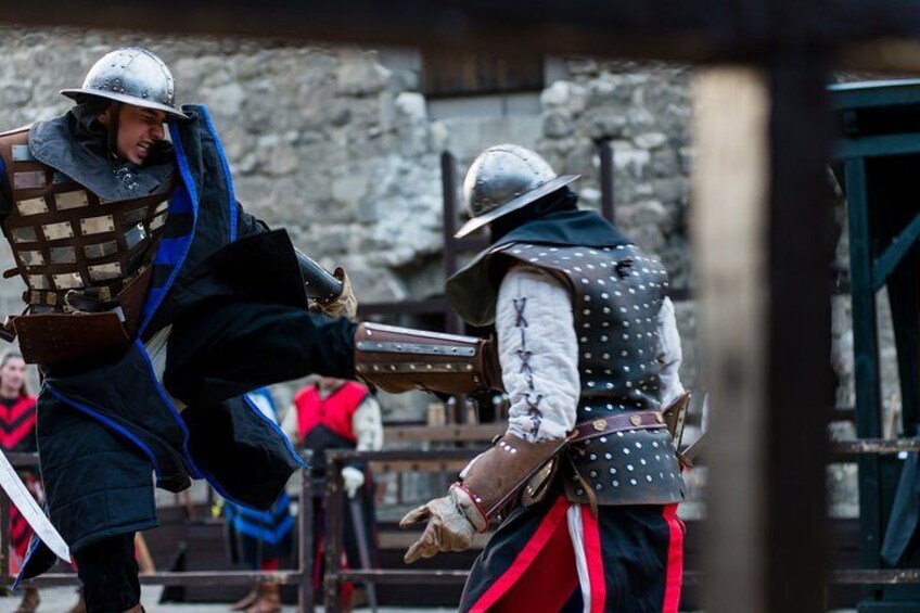 Dos personas con armadura medieval luchando en un simulacro de combate. 3