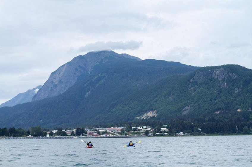Un lago con kayakistas y una montaña al fondo. 3