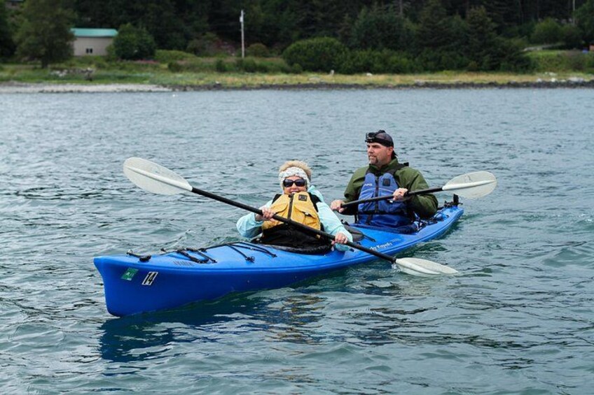 Dos personas remando en kayak sobre aguas tranquilas. 5