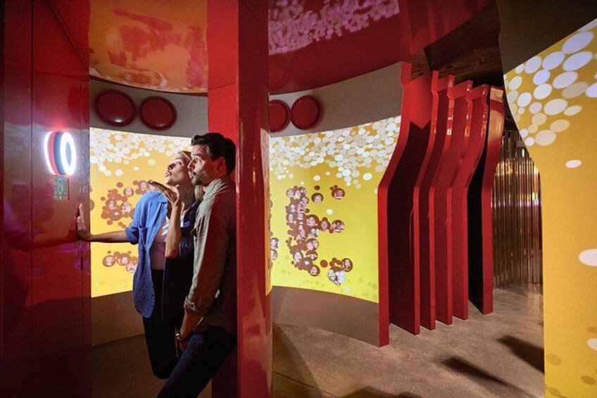 A modern interior with red and yellow walls, geometric patterns, and a circular light fixture. 2