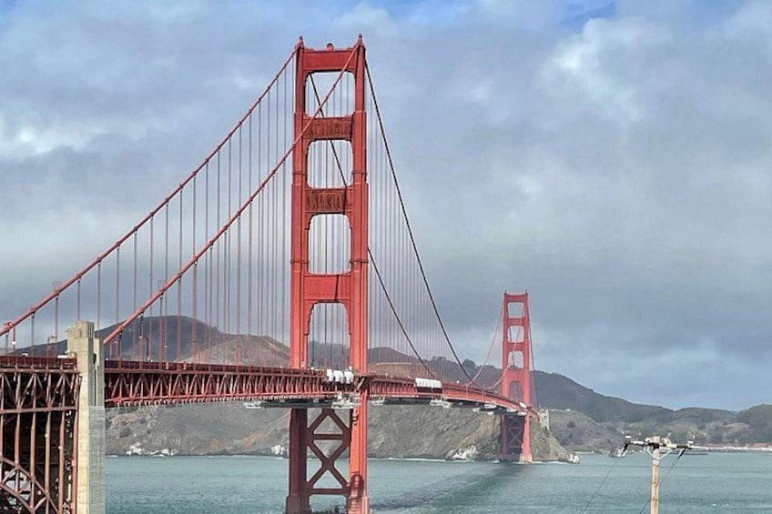 The Golden Gate Bridge with its towers and suspension cables, and the surrounding water and hills. 3